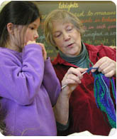 teacher instructing student how to knit